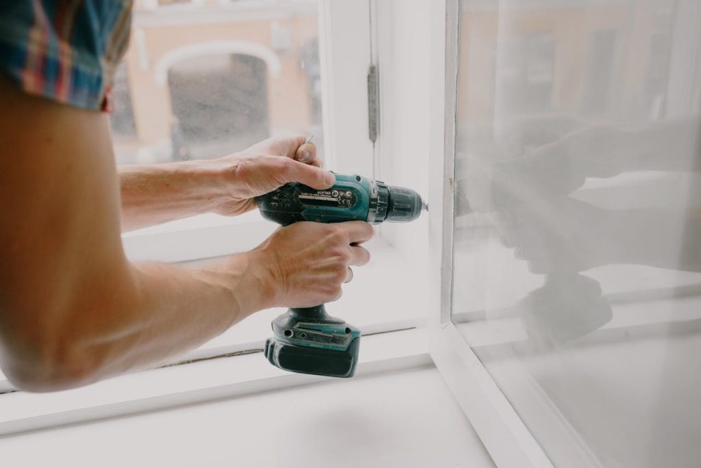 workman-screwing-window-frame-during-housework-5768107 Workman screwing window frame during housework